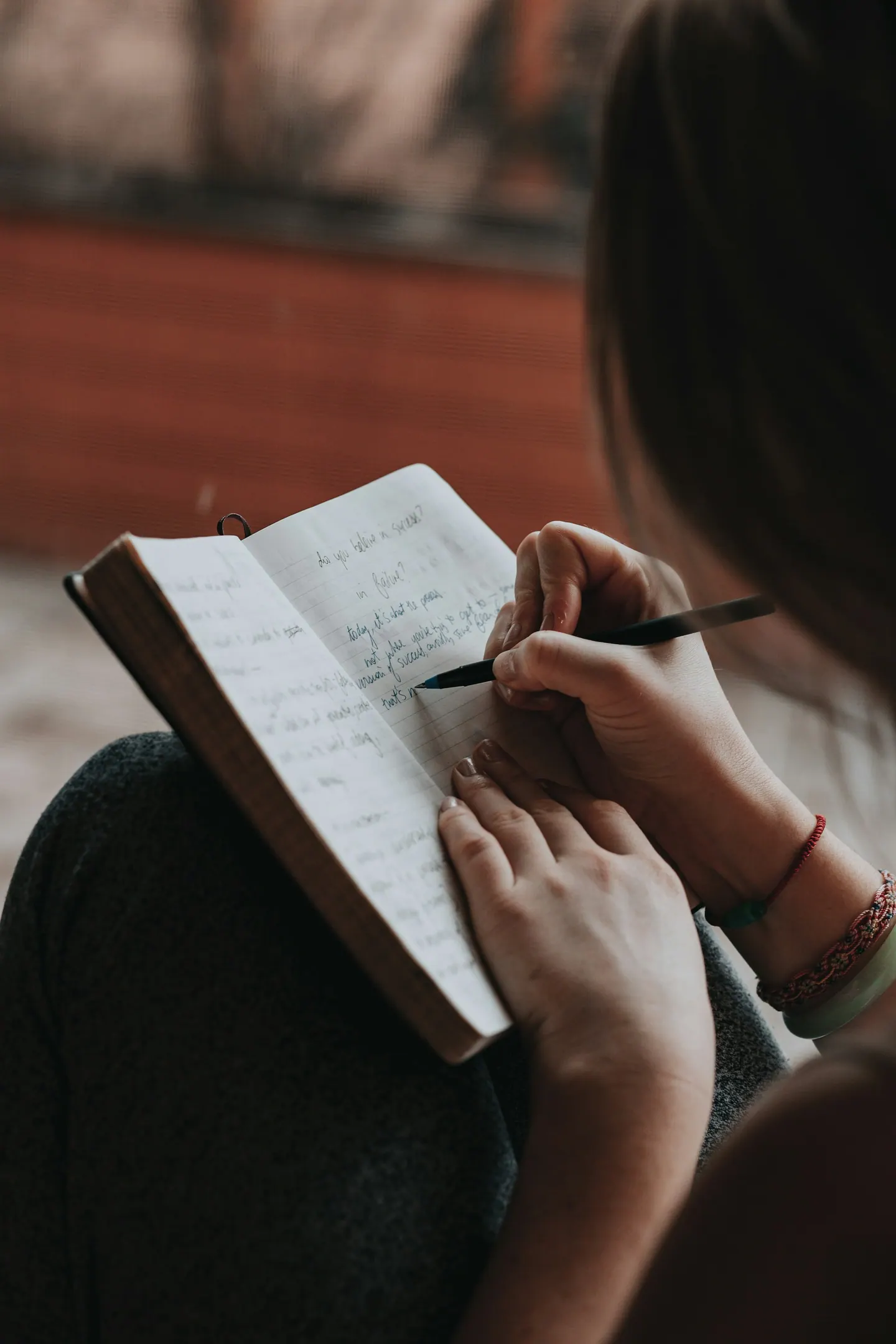 A woman writing in an open notebook